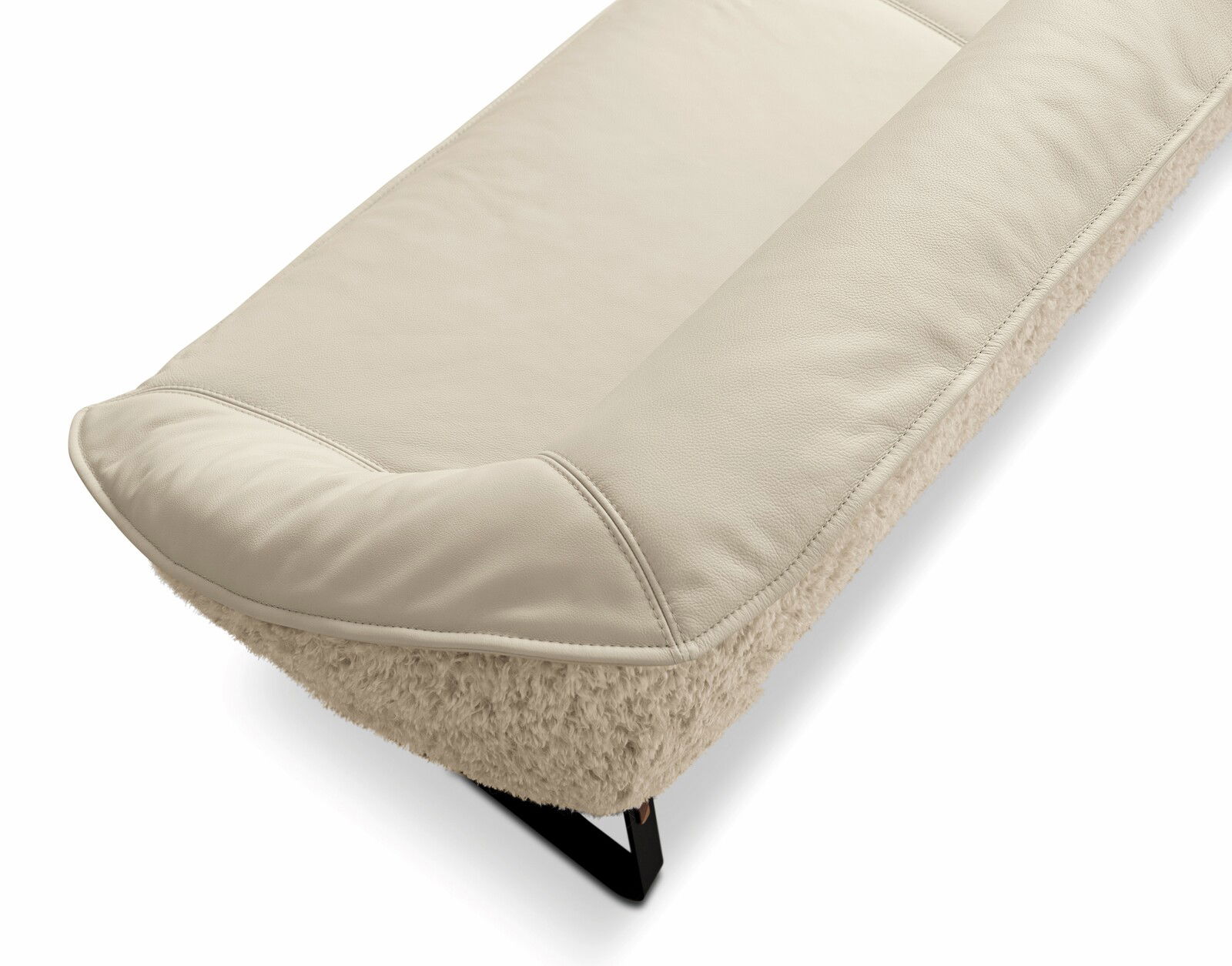 Nahaufnahme einer cremefarbenen Bank mit weicher Polsterung und schwarzem Metallfuß, seitliche Perspektive.