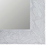 Detailansicht eines Spiegels mit dekorativem, strukturiertem Rahmen in Weiß.