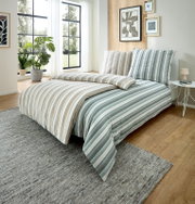 Gestreifte Bettwäsche in Beige und Mintgrün auf einem modern eingerichteten Bett im hellen Schlafzimmer, Perspektive: schräg von vorne leicht erhöht.