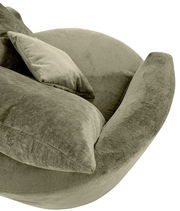 Nahaufnahme eines grünen Sessels mit weichem Stoffbezug und passendem Kissen, seitliche Perspektive