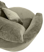 Nahaufnahme eines grünen Sessels mit weichem Stoffbezug und passendem Kissen, seitliche Perspektive