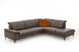 Ecksofa in braunem Leder mit zwei orangefarbenen Kissen, Perspektive von vorne links
