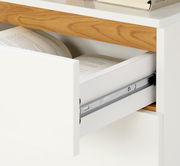 Nahaufnahme eines Schreibtischs mit einer geöffneten Schublade, die Bücher enthält. Die Perspektive zeigt die rechte Seite des Schreibtischs.