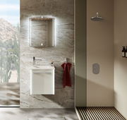 Modernes Gästebad mit beleuchtetem Spiegel, Waschbeckenunterschrank und Regendusche, seitliche Perspektive.