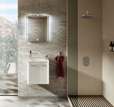 Modernes Gästebad mit beleuchtetem Spiegel, Waschbeckenunterschrank und Regendusche, seitliche Perspektive.