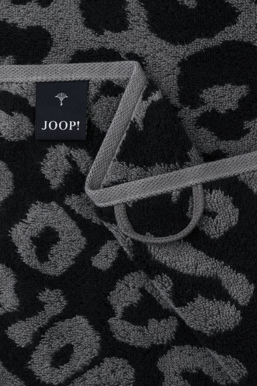 Nahaufnahme eines Handtuchs mit grauem und schwarzem Leopardenmuster und einem JOOP!-Label.