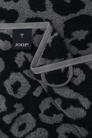Nahaufnahme eines Handtuchs mit grauem und schwarzem Leopardenmuster und einem JOOP!-Label.