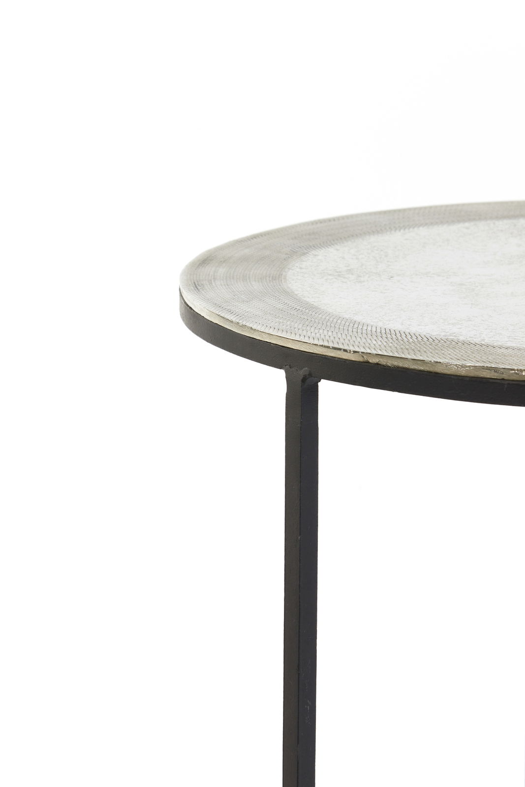 Nahaufnahme eines runden Beistelltisches mit Metallgestell und strukturierter Tischplatte, seitliche Perspektive.