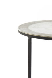 Nahaufnahme eines runden Beistelltisches mit Metallgestell und strukturierter Tischplatte, seitliche Perspektive.