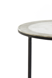 Nahaufnahme eines runden Beistelltisches mit Metallgestell und strukturierter Tischplatte, seitliche Perspektive.