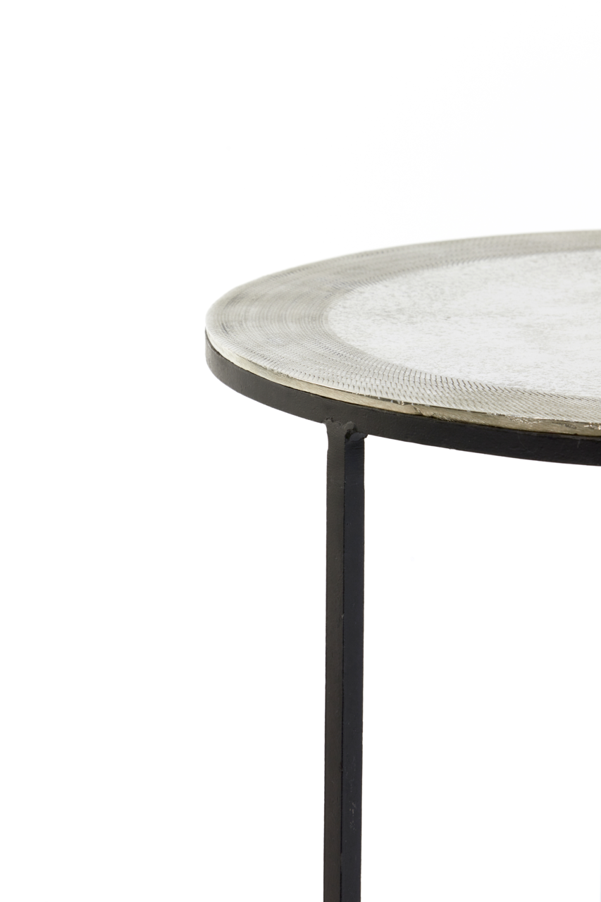 Nahaufnahme eines runden Beistelltisches mit Metallgestell und strukturierter Tischplatte, seitliche Perspektive.