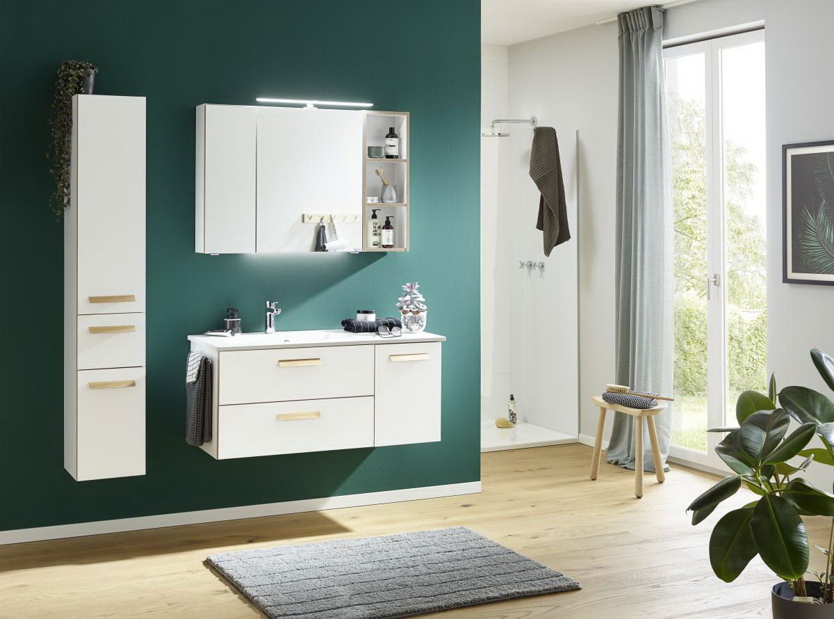 Moderne Badkombination in Weiß mit Holzgriffen, bestehend aus einem Waschtisch mit Schubladen, einem Hängeschrank und einem Spiegel mit Beleuchtung. Perspektive: Frontalansicht.