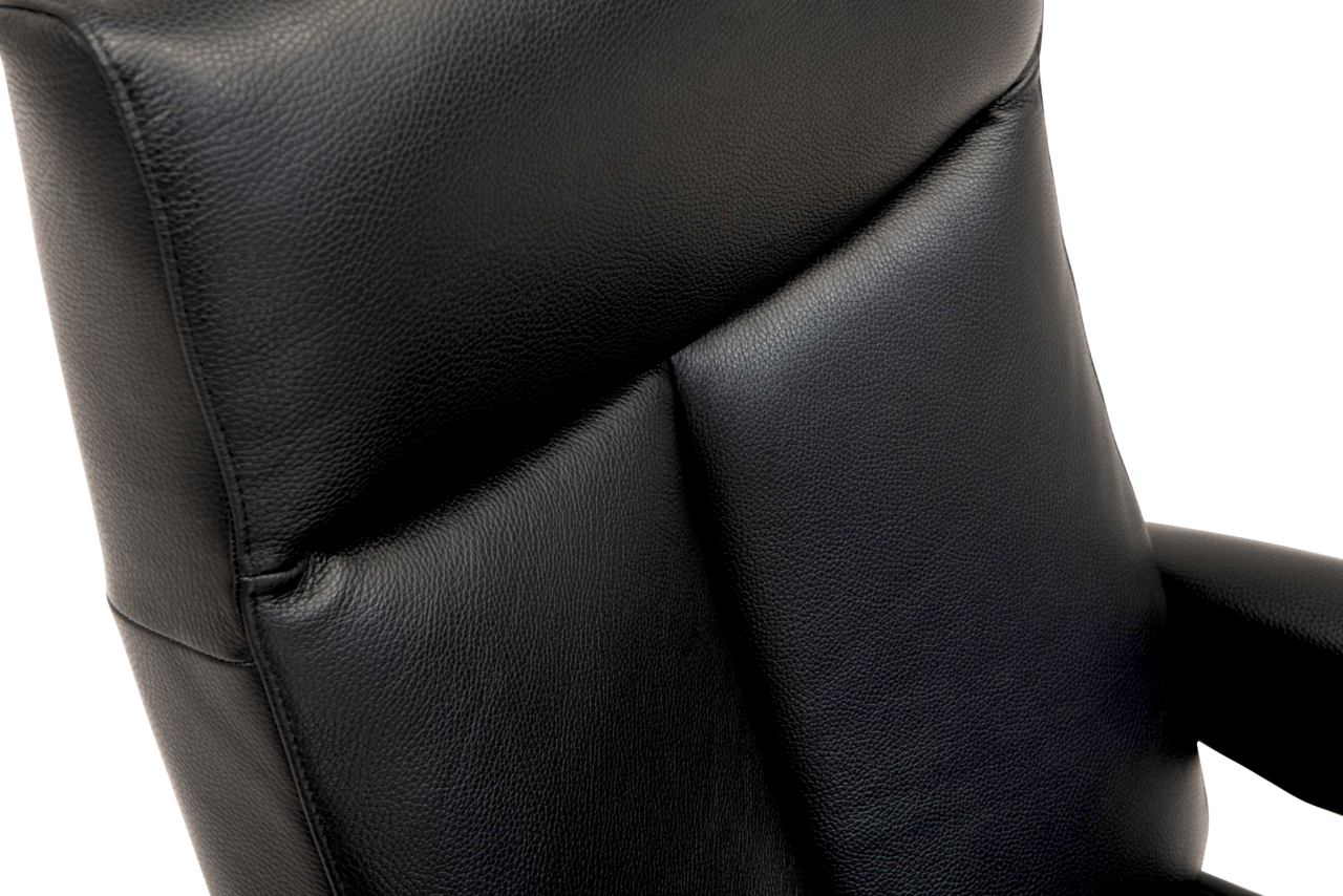 Nahaufnahme eines schwarzen Relaxsessels aus Leder, Ansicht von der Seite.