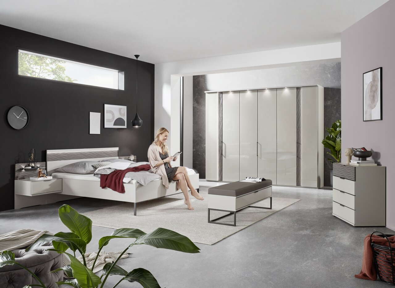 Moderne Schlafzimmeransicht mit Nachtkonsolen, Bett und Schrank in einem stilvollen, hellen Raum.