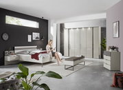 Een moderne slaapkamer met nachtkastjes, een bed en een kast in een stijlvolle, lichte ruimte.