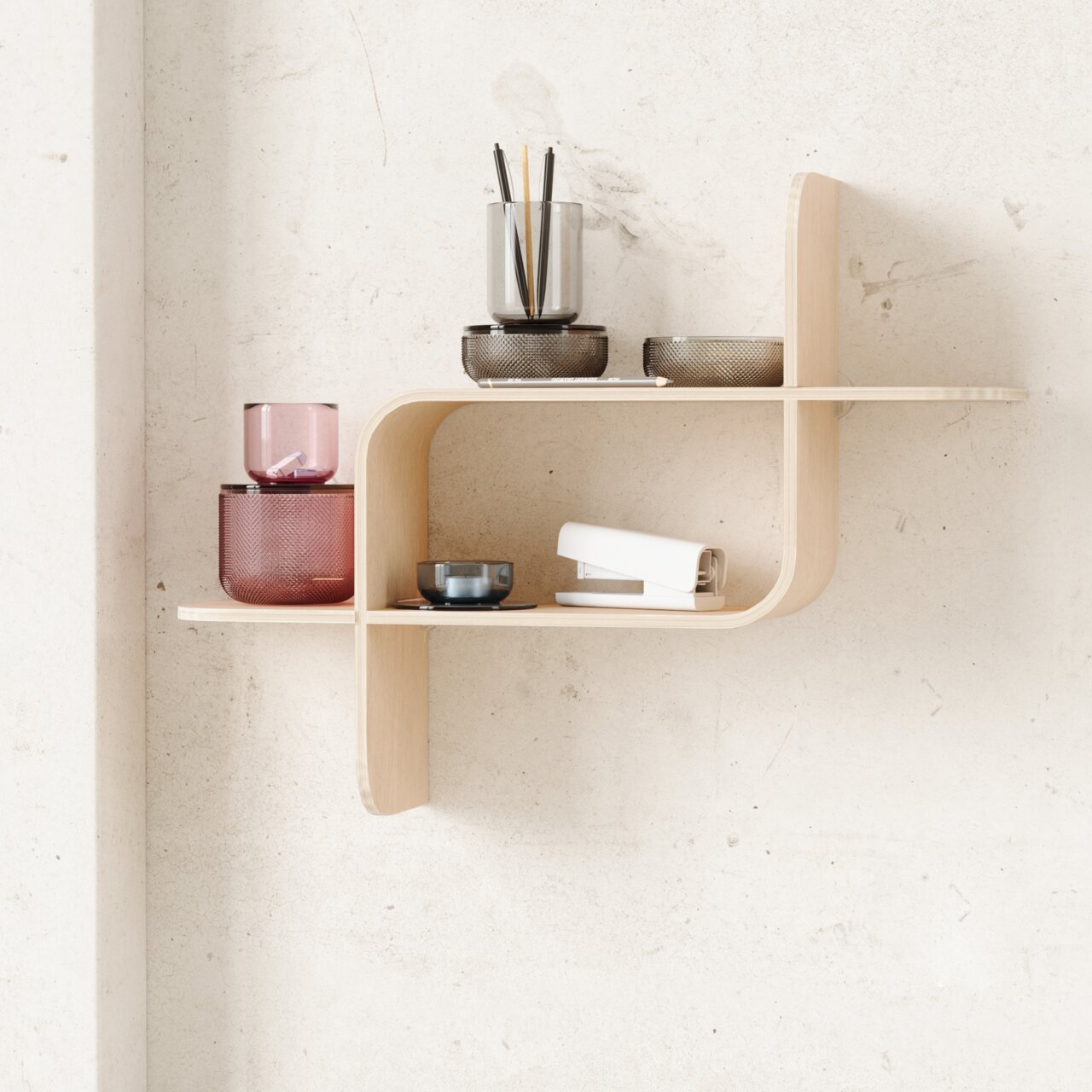 Modernes Wandregal aus hellem Holz mit geschwungenem Design, dekoriert mit farbigen Gläsern und Büroartikeln, seitliche Perspektive.