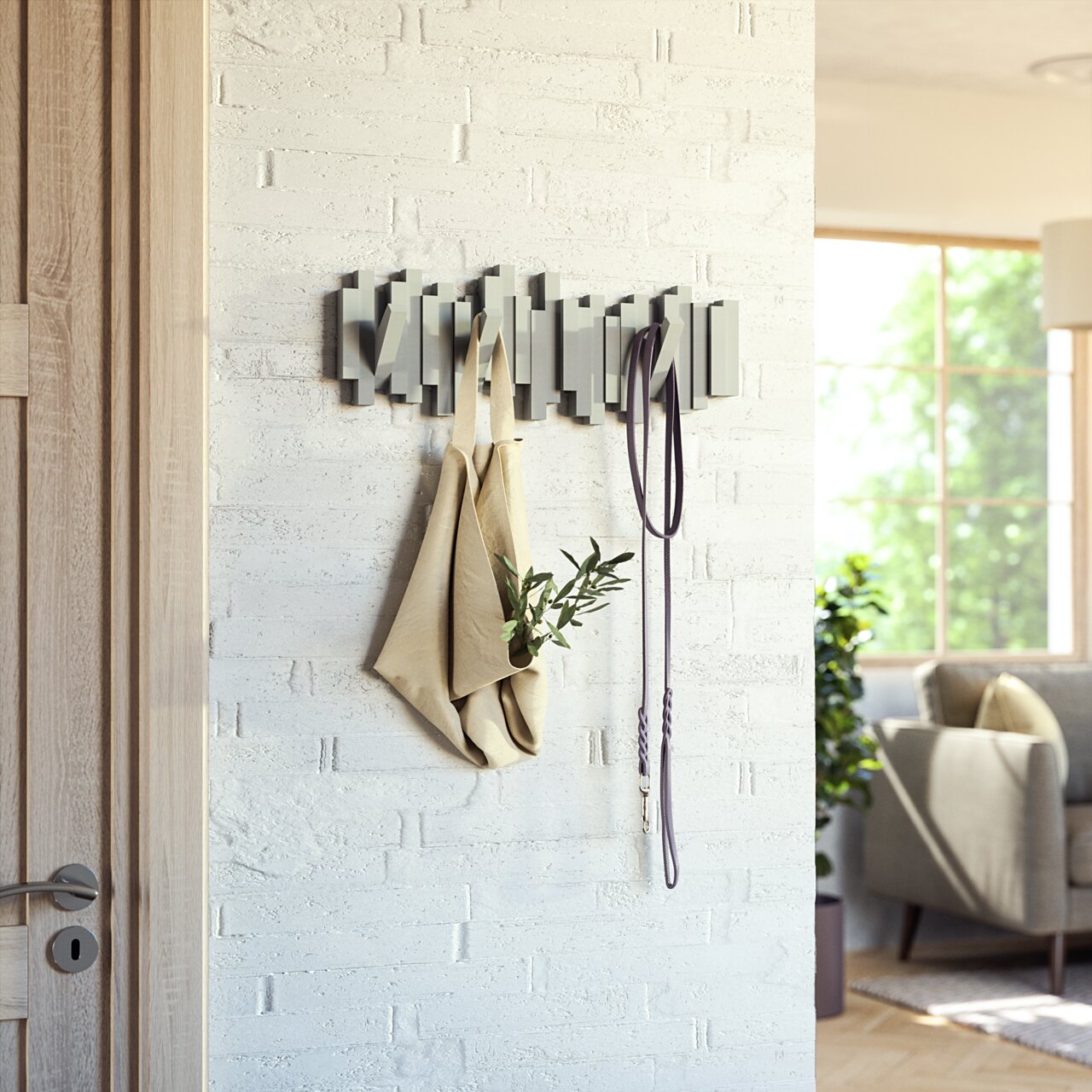 Moderne Wandgarderobe aus Holz mit geometrischem Design, frontal an einer weißen Ziegelwand montiert, mit aufgehängter Tasche und Leine.