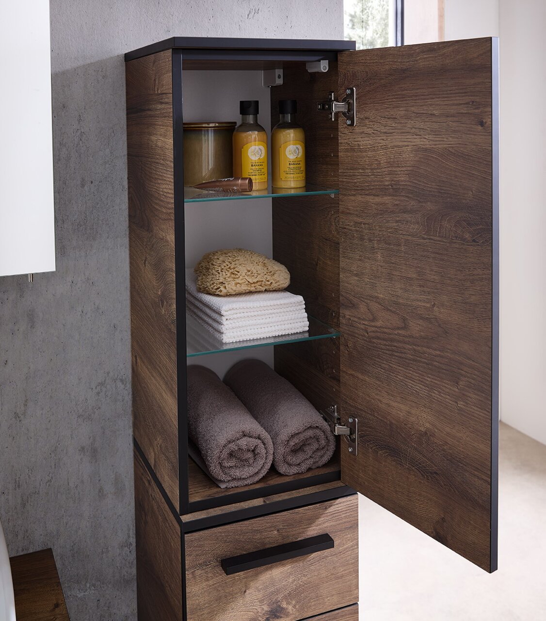 Geöffneter Wandschrank aus Holz mit zwei Regalböden, gefüllt mit Handtüchern, Schwamm und Pflegeprodukten, seitliche Perspektive