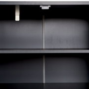 Innenansicht eines modernen, grauen Sideboards mit zwei Regalböden, frontal betrachtet.