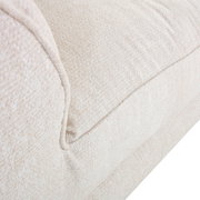Nahaufnahme eines cremefarbenen Big-Sofas mit weicher Textur, seitliche Perspektive.