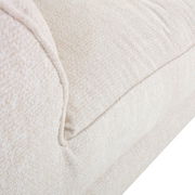 Nahaufnahme eines cremefarbenen Big-Sofas mit weicher Textur, seitliche Perspektive.