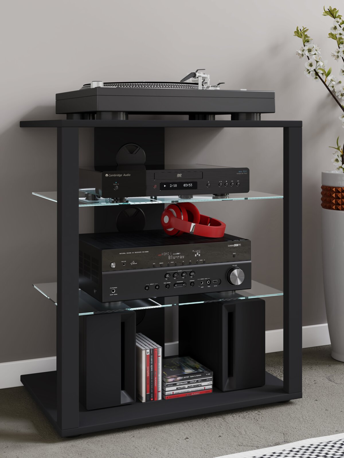 Schwarzes HiFi- und TV-Rack mit Glasböden, darauf ein Plattenspieler und darunter Audio-Komponenten, rote Kopfhörer sowie Lautsprecher und CDs frontale Perspektive auf das Möbel