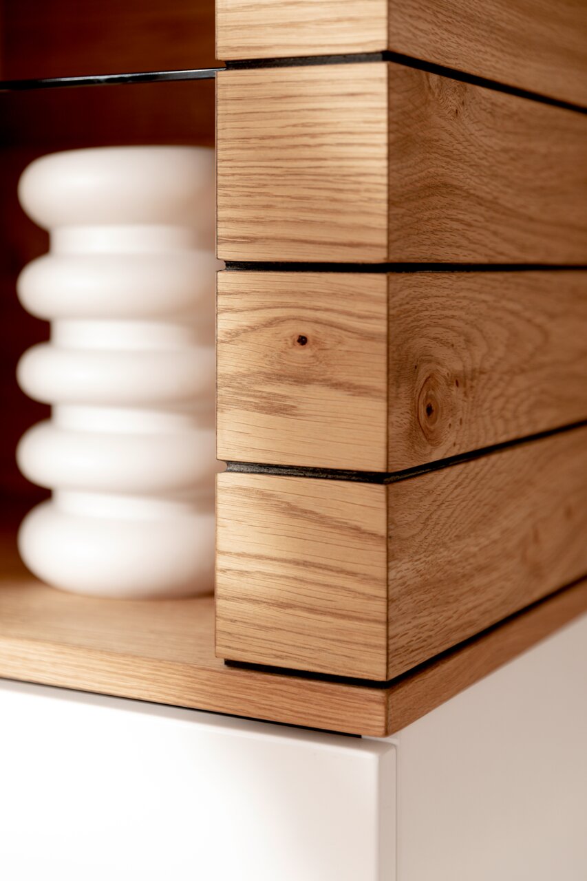 Nahaufnahme eines Highboards aus Holz mit klaren Linien und moderner Gestaltung, seitliche Perspektive