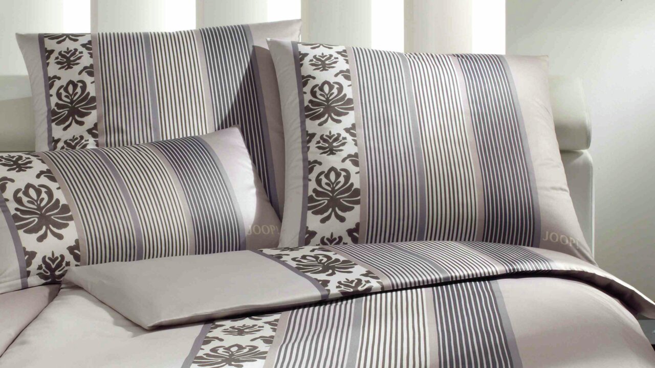 Kissenbezug mit Ornament- und Streifenmuster in Grau- und Beigetönen, seitliche Perspektive