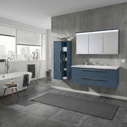 Modernes Badezimmer mit blauem Waschtischunterschrank, weißem Waschtisch und LED-Spiegelschrank sowie passendem Hochschrank; frontale Ansicht mit leichter Perspektive von links.