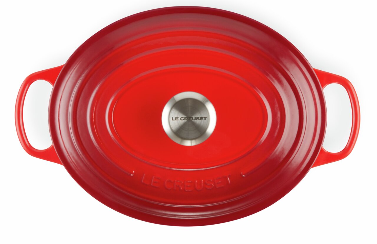 Roter ovaler Bräter von oben mit zwei Griffen und einem silbernen Knauf, Markenname Le Creuset sichtbar.