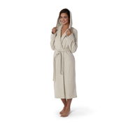 Frau in einem beigen Kapuzenbademantel, stehend in Frontalansicht, mit Kapuze aufgesetzt und Gürtel gebunden.