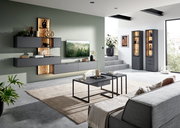 Moderne Wohnzimmer-Wandkombination in dunklem Grau mit Holzakzenten, stilvoll dekoriert, aus der Perspektive eines gemütlichen Wohnzimmers mit Sofa und Couchtischen.