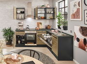 Moderne Küche mit Eckunterschrank, offener Geschirrspüler und Herd, aus der Perspektive eines Esstisches fotografiert.