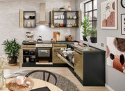 Moderne Küche mit Eckunterschrank, offener Geschirrspüler und Herd, aus der Perspektive eines Esstisches fotografiert.