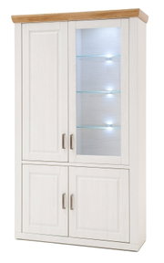 Hoge witte vitrinekast met houten kroonlijst aan de bovenkant, vier deuren, rechtsboven een glazen deur met verlichte glazen planken en metalen handgrepen, vooraanzicht vanuit een licht rechts perspectief