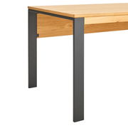 Nahaufnahme eines modernen Schreibtischs mit Holzplatte und schwarzen Metallbeinen, seitliche Perspektive