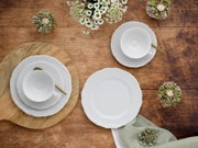 Kaffeeservice 18-tlg aus weißem Porzellan, bestehend aus Tassen, Untertassen und Tellern, auf einem Holztisch von oben fotografiert, dekoriert mit kleinen Blumenarrangements.