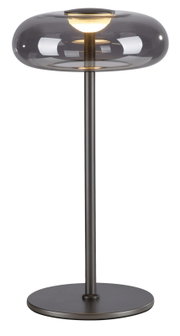 Moderne Tischleuchte mit rauchgrauem Glas-Schirm und schwarzem Metallfuß, eingeschaltet, freigestellt auf weißem Hintergrund, Frontansicht