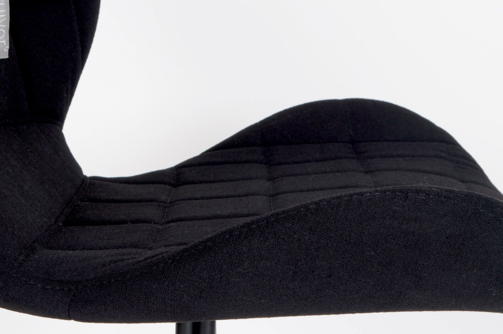 Nahaufnahme eines schwarzen, gepolsterten Stuhlsitzes mit gestepptem Design, seitliche Perspektive.