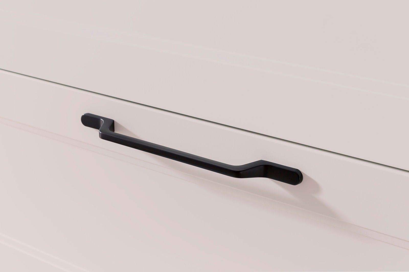 Nahaufnahme eines schwarzen Griffs an einem weißen Waschtisch, seitliche Perspektive