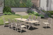Moderner Garten Ausziehtisch mit acht Stühlen in einem grünen Garten, seitliche Perspektive