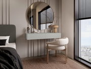 Moderne wandconsole in een stijlvolle slaapkamer, met daarboven een ronde spiegel en ervoor een elegante stoel, gezien vanuit de zijkant.