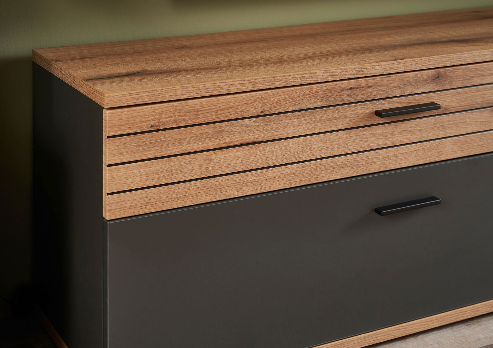 Nahaufnahme eines modernen TV-Lowboards mit Holz- und dunklen Elementen, seitliche Perspektive