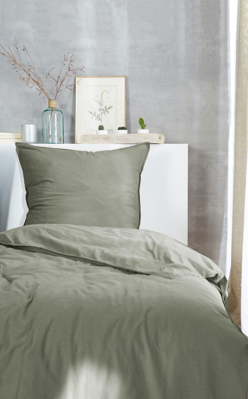Westminister Bettwäsche STONE-WASHED Grüne Bettwäsche 135x200cm auf einem Bett, fotografiert aus der Vorderansicht, mit dekorativen Elementen im Hintergrund.
