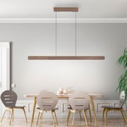 Moderne Pendelleuchte ADRIANA ROUND in Holzoptik, hängend über einem Esstisch, seitliche Perspektive.