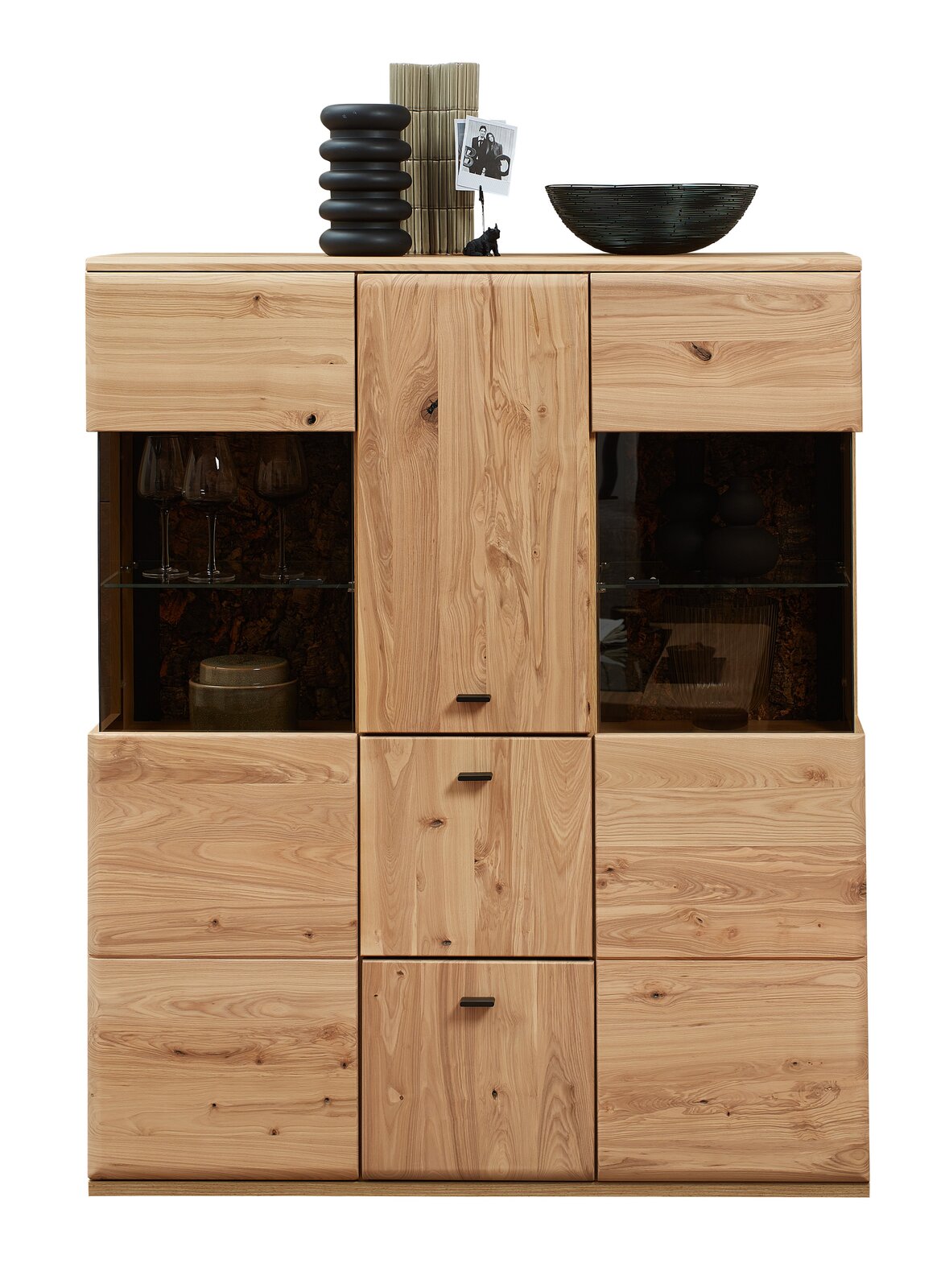Cantus Highboard CALMERA Frontale Ansicht eines Highboards aus Holz mit mehreren Schubladen und Glastüren, dekoriert mit Vasen und einer Schale.