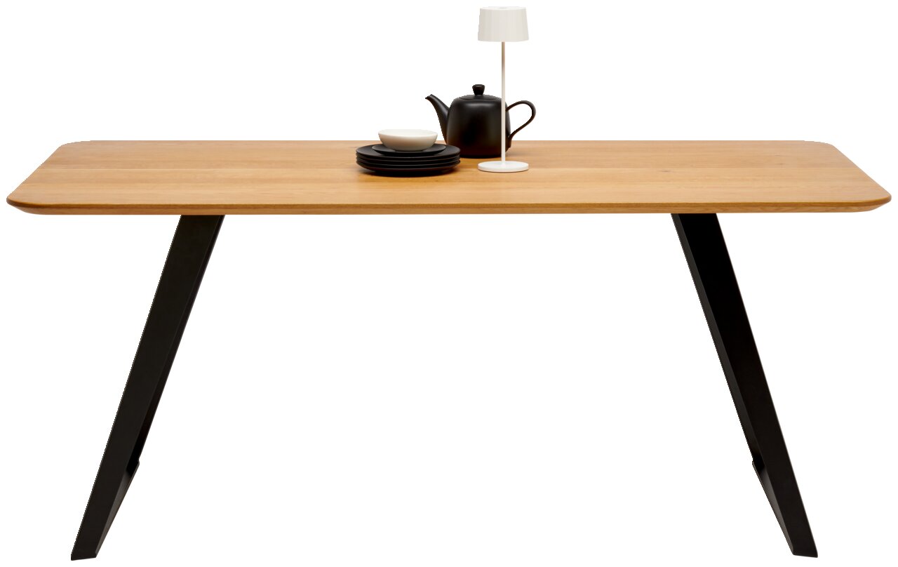 Moderner Esstisch aus Holz mit schwarzen Metallbeinen, seitliche Perspektive, dekoriert mit Geschirr und Lampe.