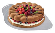 Tortenretter aus Edelstahl mit einer dekorativen Torte, die mit frischen Beeren und Schokoladensauce verziert ist, aus der Vogelperspektive.