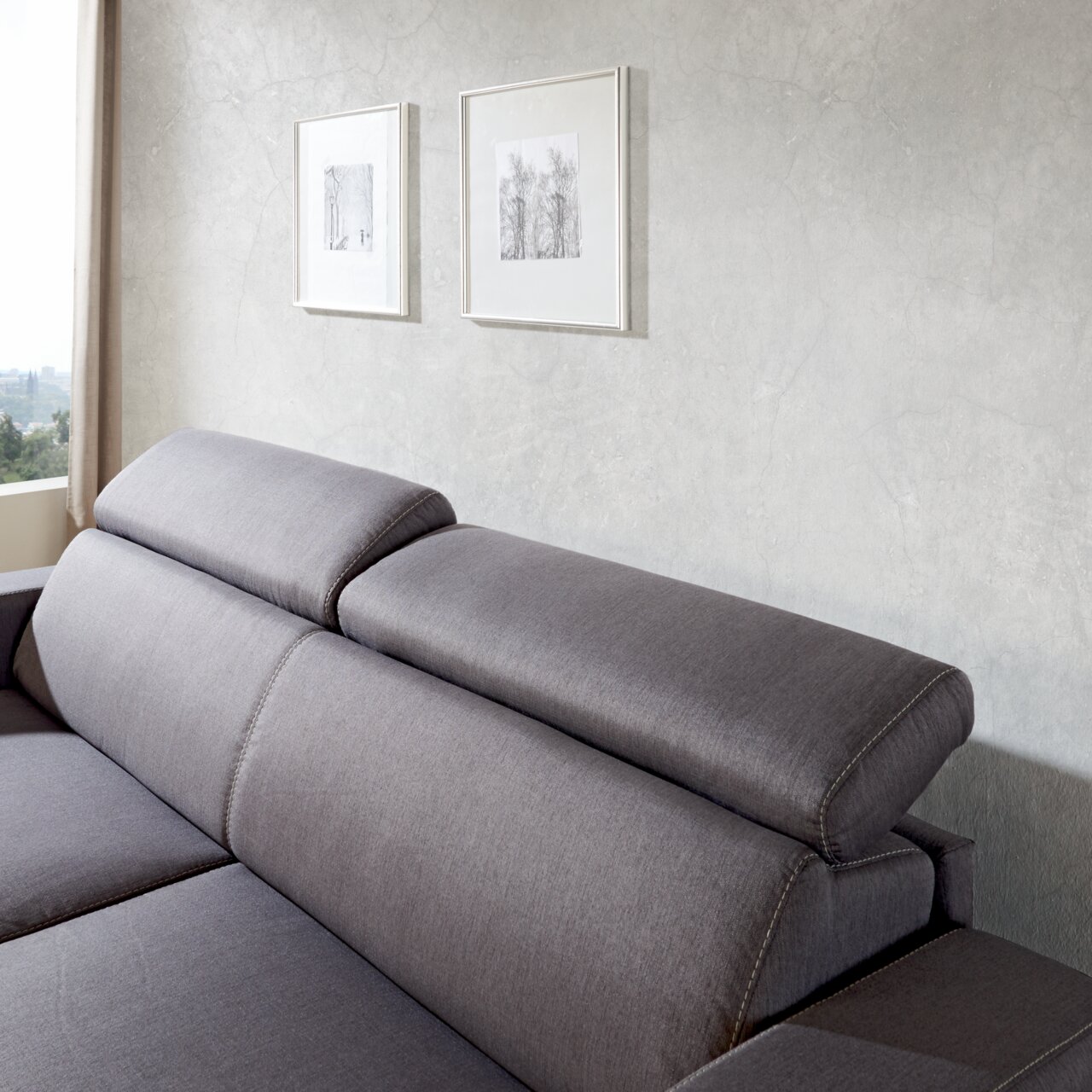 Graues Funktionssofa mit verstellbaren Kopfstützen, seitliche Perspektive