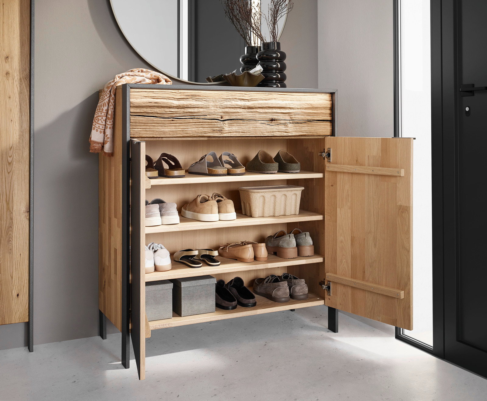 Moderner Schuhschrank aus Holz mit geöffneter Tür, gefüllt mit verschiedenen Schuhen, in einer stilvollen Inneneinrichtung. Frontalansicht.